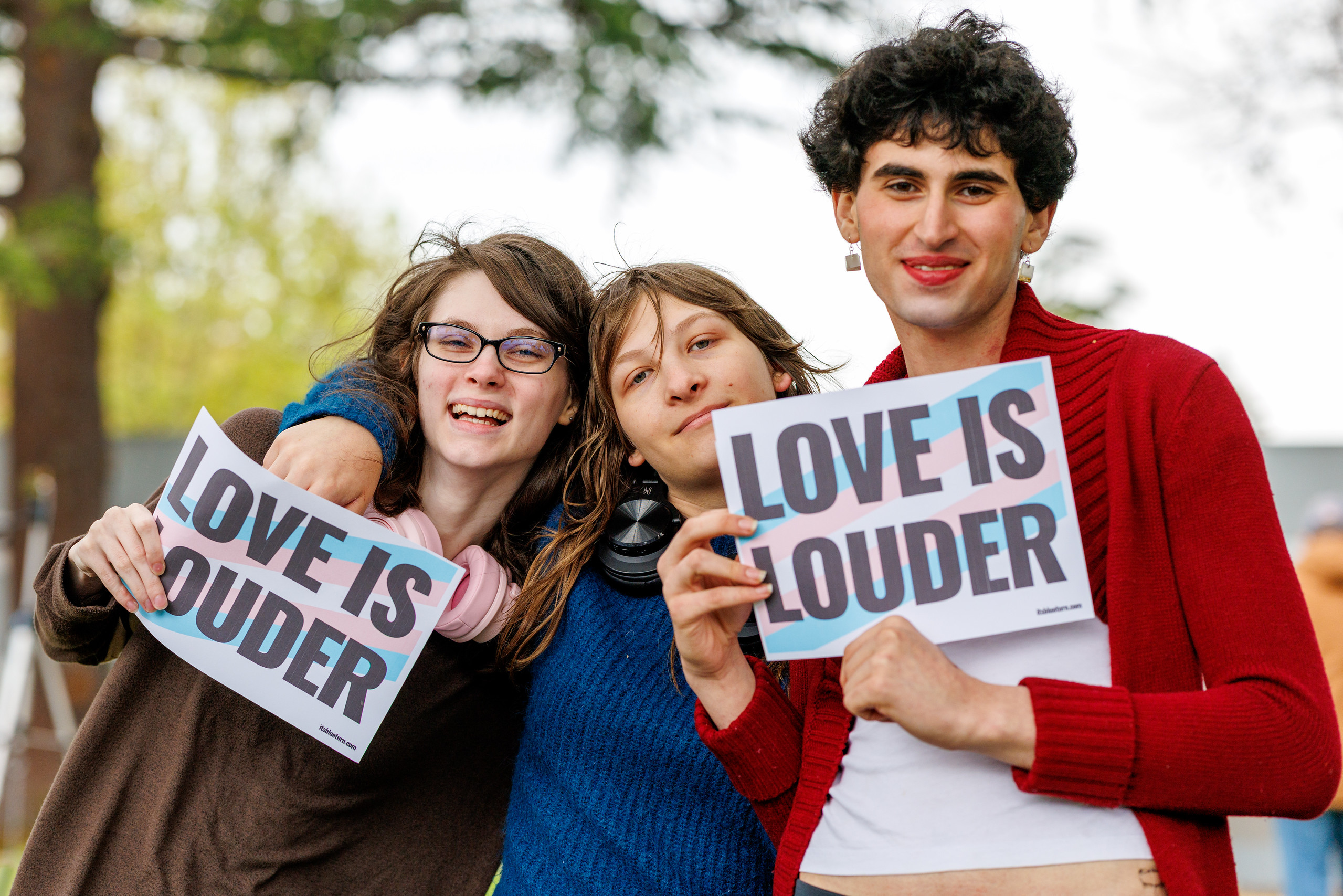 A child draws a trans pride flag in chalk on the sidewalk. Photo by Seeger Gray.
